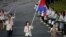 Cambodia's flagbearer Davin Sorn holds the national flag as she leads the contingent in the athletes parade during the opening ceremony of the London 2012 Olympic Games at the Olympic Stadium July 27, 2012. REUTERS/Mike Blake