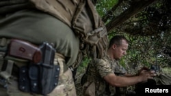 Український військовослужбовець керує FPV-дроном зі своєї позиції на передовій поблизу села Роботине, Запорізька область.