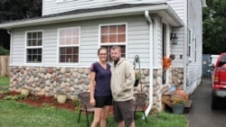 Kristal i Kris Martin ispred kuće, a jedno od šestoro dece viri kroz vrata (Foto: AP/Tammy Webber)