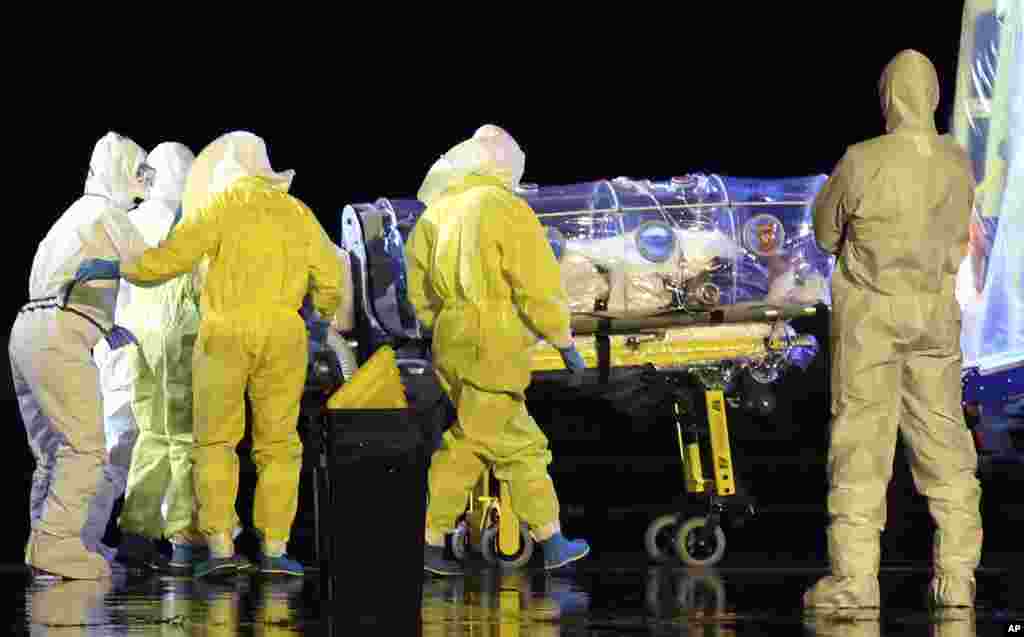 Aid workers and doctors move Manuel Garcia Viejo, a Spanish priest who was diagnosed with Ebola while working in Sierra Leone, into an ambulance as he leaves the Torrejon de Ardoz military airbase, near Madrid, Spain, Sept. 22, 2014 