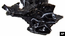 This photo released Thursday Jan. 23, 2020 by Herculaneum press office in Naples, southern Italy, shows a fragment of brain material of a victim incinerated by the ancient blast of Mount Vesuvius, and turned into glass. 