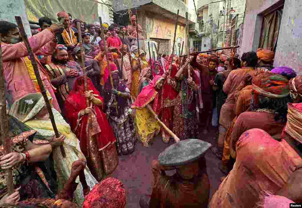 Veiled Hindu women playfully beat men with bamboo sticks as they take part in "Lathmar Holi" celebrations in the town of Nandgaon, Uttar Pradesh, India.