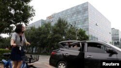 2018年8月28日，北京的滴滴出行公司大樓前面，有乘客使用該公司的快車服務。