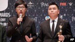 Hong Kong movie producer Andrew Choi, right, and director Ng Ka-leung pose after winning the Best Film award for their movie “Ten Years” during the Hong Kong Film Awards in Hong Kong, Sunday, April 3, 2016.
