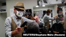 France, Mayenne, French hairdresser Marc Mauny tends to his first customer during the re-opening
