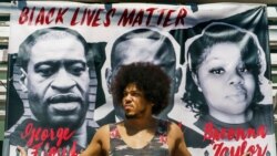 Glumac Stiven Tompson ispred postera Džordža Flojda u Los Anđelesu, 2. aprila 2021.