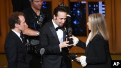 Barbra Streisand, right, presents the award for best musical to Lin-Manuel Miranda, center, of "Hamilton," as producer Jeffrey Seller looks on at the Tony Awards at the Beacon Theatre on Sunday, June 12, 2016.