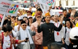 FILE - Indonesian President Joko Widodo, center right, walks with his running mate Ma'ruf Amin during a ceremony marking the kick-off of the campaign period for next year's election in Jakarta, Sept. 23, 2018.