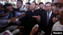 FILE-Cambodia's Prime Minister Hun Sen (2nd R), speaks to media after a meeting at the National Assembly in central Phnom Penh August 8, 2014. 