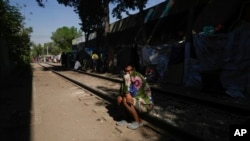 Un migrante de Maracaibo, Venezuela, sentado en una vía de ferrocarril bordeada de tiendas de campaña improvisadas donde los migrantes se refugian en la Ciudad de México, el martes 26 de marzo de 2024.