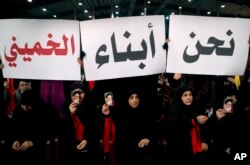 FILE - Hezbollah supporters hold up Arabic placards that read, "We are the sons of Khomeini," during a rally to commemorate the 40th anniversary of Iran's Islamic Revolution, in southern Beirut, Feb. 6, 2019.