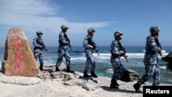Soldiers of China's People's Liberation Army Navy patrol at Woody Island, in the Paracel Archipelago
