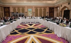FILE - A handout photo released by the official Qatari Ministry of Foreign Affairs on Feb. 26, 2019, shows Qatari officials, center, taking part in meetings between the U.S. delegation, left, and the Taliban delegation in Doha.