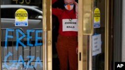 Manifestante pro-Palestina levanta los puños mientras ocupa el vestíbulo de un edificio en el que se encuentra el consulado israelí en San Francisco, el lunes 3 de junio de 2024.