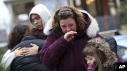 Mourners grieve at one of the makeshift memorials for victims of the Sandy Hook Elementary School shooting, December 16, 2012, in Newtown, Connecticut. 