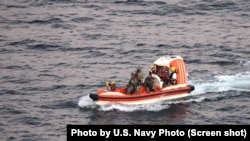 پرسنل نیروی دریایی ایالات متحده در حال انتقال یک دریانورد ایرانی در دریای عمان. شنبه ۶ آذر ۱۴۰۰