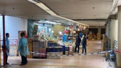 多名穿上保護衣的警員封鎖連接康美樓及街市的一個出入口。(美國之音 湯惠芸拍攝)