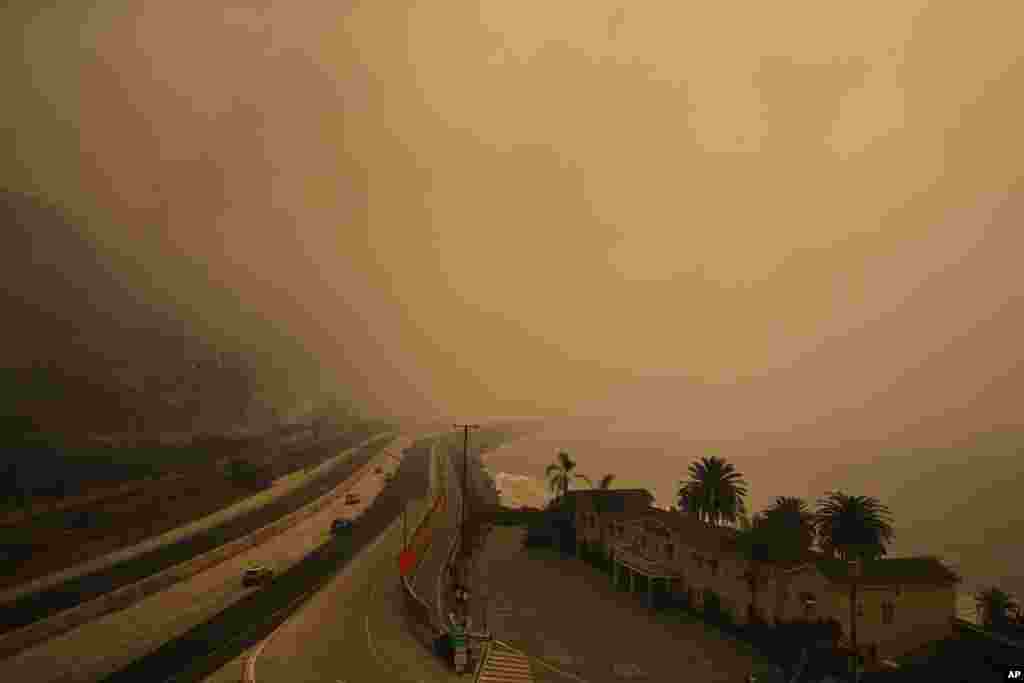 Traffic moves along the 101 Freeway as smoke from a wildfire fills the air in Ventura, California, Dec. 7, 2017. 