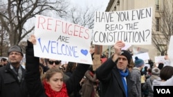 Protesters carry signs outside the White House during a protest to denounce President Donald Trump's executive order that blocks the arrival of all refugees to the United States, Sunday, Washington, Jan. 29, 2017. (Photo: S. Islam/VOA)