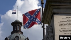The U.S. flag and South Carolina state flag flies at half staff to honor the nine people killed in the Charleston murders as the confederate battle flag also flies on the grounds of the South Carolina State House in Columbia, SC, June 20, 2015.