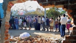 FILE - Survivors line up for aid in Armenia, El Salvador, 39 kms from the El Savadoran capital, after it was destroyed by an earthquake on January 23, 2001.