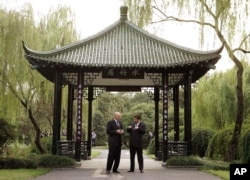 2006年9月19日，美国财政部长保尔森和中共浙江省委书记习近平在杭州的亭子交谈