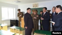 North Korean leader Kim Jong Un gives field guidance at the newly built Wisong Scientists Residential District in this undated photo released by North Korea's Korean Central News Agency (KCNA) in Pyongyang October 14, 2014. Kim, shown using a cane for sup