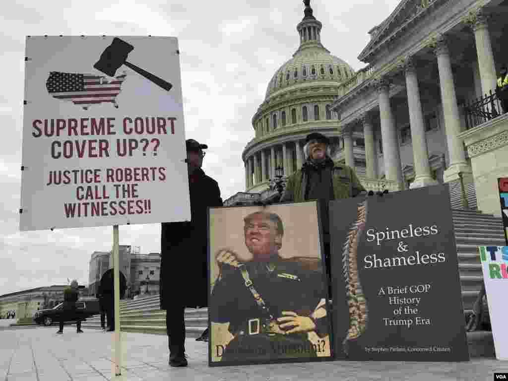 បាតុករប្រឆាំងលោកប្រធានាធិបតីសរអា Donald Trump មកពីរដ្ឋផ្សេងៗ ជាងដប់នាក់ នាំគ្នាកាន់បដានិងច្រៀងចម្រៀងស្នេហាជាតិ នៅវិមានសភា នៅមុនការចាប់ផ្កើមការរជំនុំជម្រះទោសនៅថ្ងៃសុក្រនេះ។ (ប៉ូច​ រាសី/VOA)