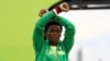 Le marathonien Feyisa Lilesa place ses bras au-dessus de sa tête lors de la remise de médaille d’argent remportée au marathon lors des Jeux olympiques, à Rio, 21 août 2016. 