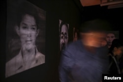 People attend an exhibition by artist Jirawut Ueasungkomsate at a gallery in Bangkok, Thailand, March 4, 2016.