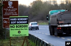FILE - A poster against a hard border stands on the border between Northern Ireland and the Republic of Ireland near the town of Derrylin, Northern Ireland, Dec. 12, 2018.