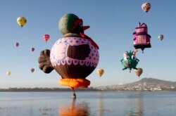 Hot-air balloons fly over the Palote dam during the "Hot Air Balloons Festival" in the city of Leon, in the state of Guanajuato, Mexico November 17, 2008. REUTERS/Mario Armas (MEXICO)