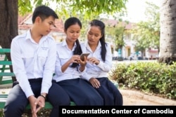 A group of youth look at the new website about Khmer Rouge on smartphone. (Photo: Ouch Makara/Documentation Center of Cambodia)
