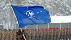 Un soldado alemán enarbola la bandera de la OTAN durante una visita de la entonces ministra de Defensa Ursula von der Leyen a la base de Rukia, Lituania, en 2019.