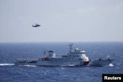 Chinese ship and helicopter are seen during a search and rescue exercise near Qilian Yu subgroup in the Paracel Islands, which is known in China as Xisha Islands, South China Sea, July 14, 2016.
