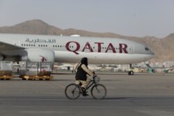 FILE - A Taliban soldier patrols on a bike in front of a Qatar Airways flight at the international airport in Kabul, Afghanistan, Sept. 10, 2021. (West Asia News Agency via Reuters)