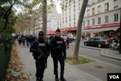 Officers patrol near a memorial outside the Bataclan Concert Hall a day after more than 120 people were killed in a series of attacks in Paris, Nov. 14, 2015.