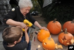 For Halloween, Betty Dillow of Bristol, Virgina helps her grandson carve his pumpkin with a power drill, 2013.