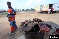 A woman walks past dried bushmeat near a road of the Yamoussoukro highway March 29, 2014. REUTERS/Thierry Gouegnon