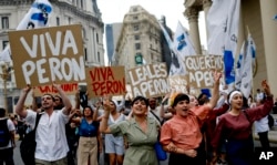 FILE - Argentinian Peronists rally at the Plaza de Mayo with cardboard posters reading in Spanish; "Long live Peron," "Loyal to Peron," "We love Peron," marking Peronist Loyalty Day, in Buenos Aires, Argentina, Oct. 17, 2013.