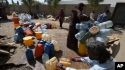 Varias personas recogen agua de un punto de suministro en una barriada de Karachi, Pakistán, el martes 21 de marzo de 2023. 