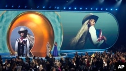 Beyonce accepts the award for album of the year for Cowboy Carter during the 67th annual Grammy Awards on Sunday, Feb. 2, 2025, in Los Angeles. Blue Ivy Carter looks on from right.