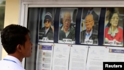 រូបឯកសារ៖ និស្សិតម្នាក់មើលរូបអតីតមេដឹកនាំជាន់ខ្ពស់ខ្មែរក្រហម មុនចូលរួមសវនាការរបស់សាលាក្តីខ្មែរក្រហម នៅជាយរាជធានីភ្នំពេញ កាលពីថ្ងៃទី ១៣ ខែធ្នូ ឆ្នាំ ២០១១។