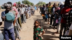 Wakimbizi wa Ethiopia wakipanga mstari kuchukuwa chakula katika kambi ya wakimbizi ya Um Rakuba inayo wahifadhi wakimbizi wanaokimbia mapigano huko Jimbo la Tigray, ilioko mpakani kati ya Ethiopia na Sudan, Nov. 28, 2020. 