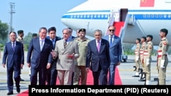 巴基斯坦总理谢里夫（中）在机场欢迎中国总理李强抵达伊斯兰堡。（2024年10月14日）