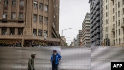 Ivan Meyer (kulia), Mwenyekiti wa Shirikisho la chama cha upinzani cha Afrika Kusini cha Democratic Alliance anaonekana kwenye eneo la ujenzi katika Wilaya ya Kati ya Biashara ya Johannesburg wakati wa kuzindua mabango ya kwanza ya uchaguzi ya Afrika Kusini.