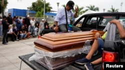Una camioneta carga un ataúd frente a la prisión Penitenciaría del Litoral, en Guayaquil, Ecuador, después de un motín carcelario que dejó al menos 61 muertos el 13 de noviembre de 2021.