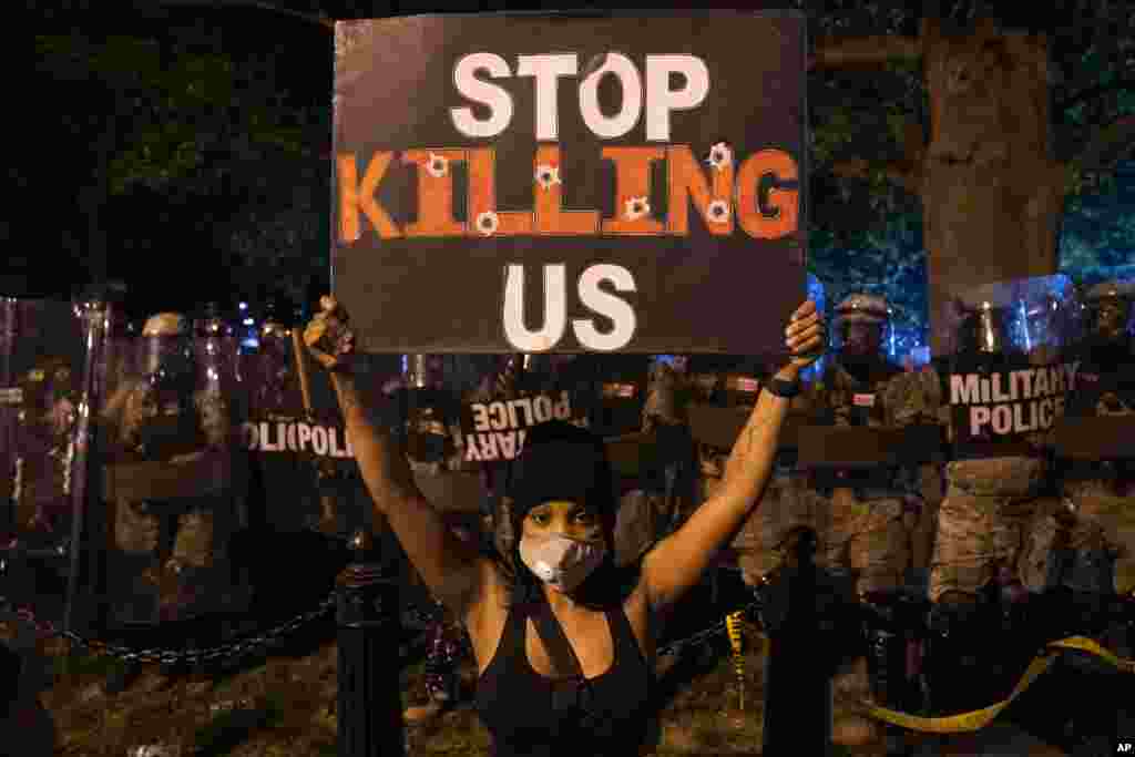 នៅក្នុង​បាតុកម្ម​នៅ​ថ្ងៃសៅរ៍ ទី ៣០ ខែឧសភា ឆ្នាំ ២០២០ ក្បែរ​សេតវិមាន​ក្នុង​រដ្ឋធានី​វ៉ាស៊ីនតោន ស្រ្តី​ម្នាក់​នេះ កាន់​ស្លាក​សញ្ញា​ដែល​សរសេរ​ថា &laquo;ឈប់​សម្លាប់​ពួកយើង&raquo; ដើម្បី​ជា​ការតវ៉ា​អំពី​ការស្លាប់​របស់​លោក George Floyd នៅ​ថ្ងៃសៅរ៍​ទី ៣០ ខែឧសភា ឆ្នាំ ២០២០ ក្បែរ​សេតវិមាន​ក្នុង​រដ្ឋធានី​វ៉ាស៊ីនតោន។&nbsp;(AP) 