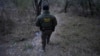 ARCHIVO: Un agente fronterizo camina por una senda llena de brazaletes usados por los traficantes de personas para el contrabando de migrantes hacia EEUU en McAllen, Texas, el 13 de febrero de 2025.