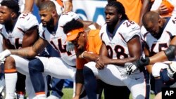 Denver Broncos players kneel during the national anthem prior to an NFL football game against the Buffalo Bills, in Orchard Park, New York.